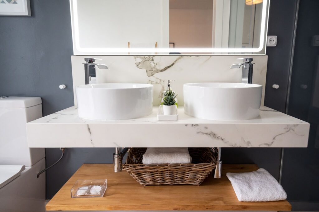 Bathroom with dual sinks, mirror, soapstone and quartz countertops.