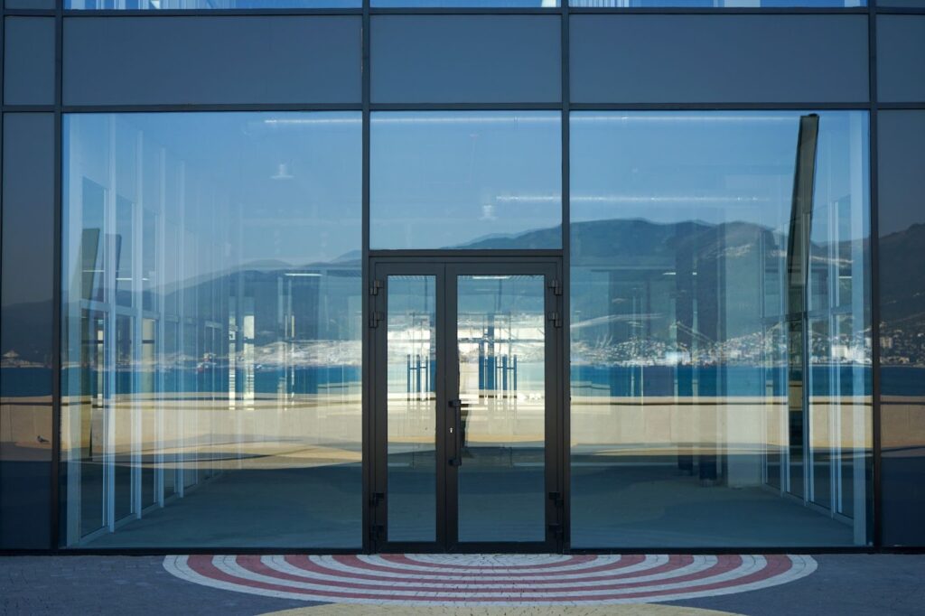 A large glass door stands above a circular floor pattern, complemented by elegant granite stone countertops.